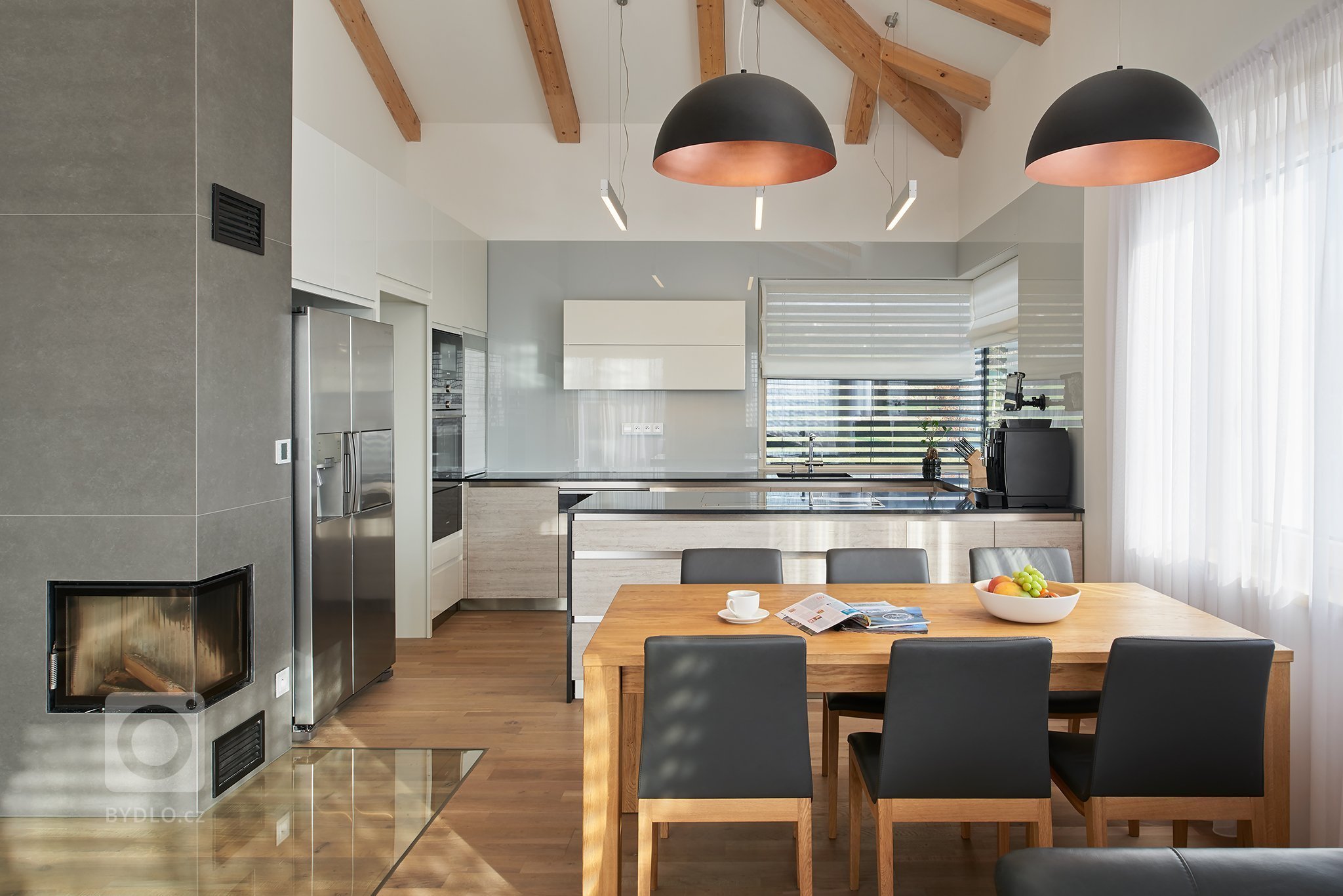 Moderní interiér domu v obývací části s vysokým stropem kde konstrukce krovu ze smrkových trámů zůstala&nbsp;částečně viditelná. Interiér dýchá příjemnou…