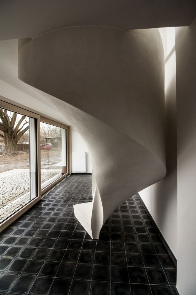 Betonová litá schodiště zpravidla vyžadují opravné úpravy povrchu, které se řeší stěrkou. Stěrka může však být použita na schodišti i k samotnému dekorování, jako například u tohoto bílého schodiště s moniérkou. Stěrkování schodiště vyžaduje precizní práci v hranách a velký smysl pro detail.