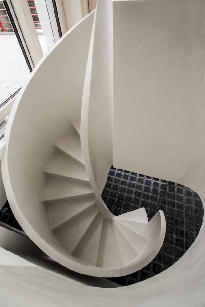 Betonová litá schodiště zpravidla vyžadují opravné úpravy povrchu, které se řeší stěrkou. Stěrka může však být použita na schodišti i k samotnému dekorování, jako například u tohoto bílého schodiště s moniérkou. Stěrkování schodiště vyžaduje precizní práci v hranách a velký smysl pro detail.