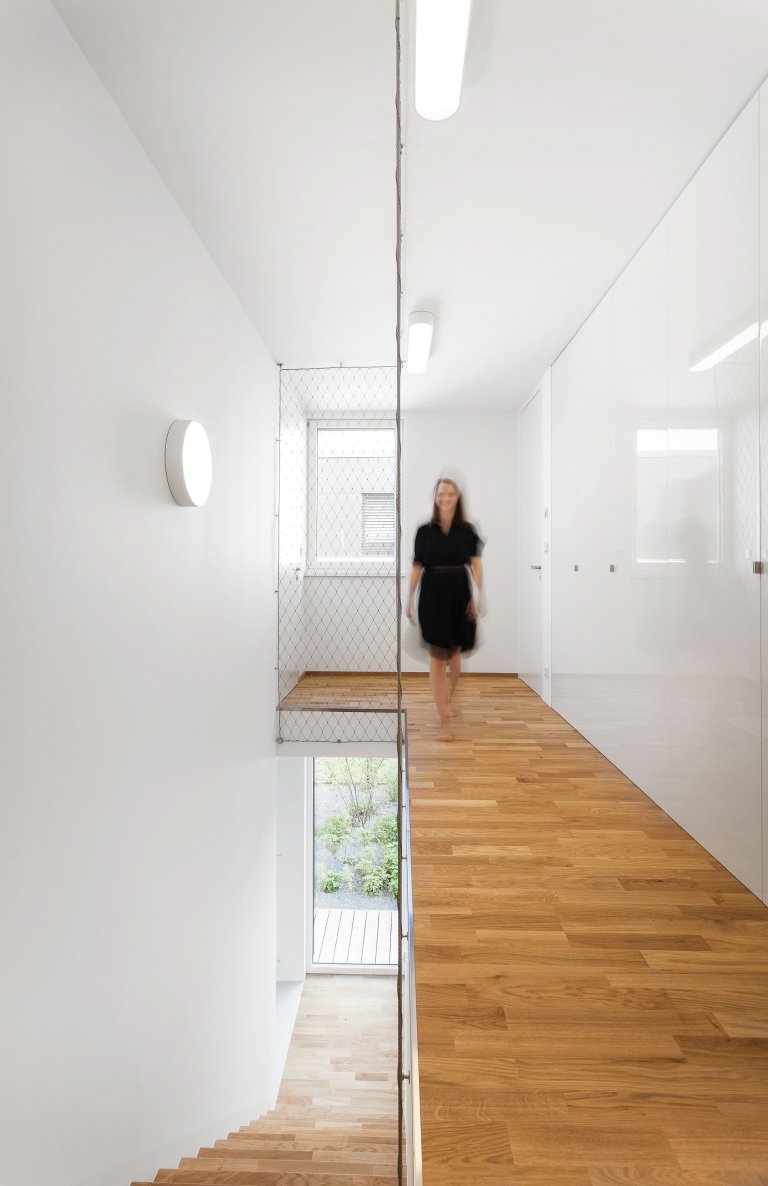 Strohá geometrie a bílá barva v&nbsp;kombinaci s&nbsp;přírodním olejovaným dubem a antracitově šedými plochami jako podklad pro barevné hrátky v&nbsp;prostoru.…