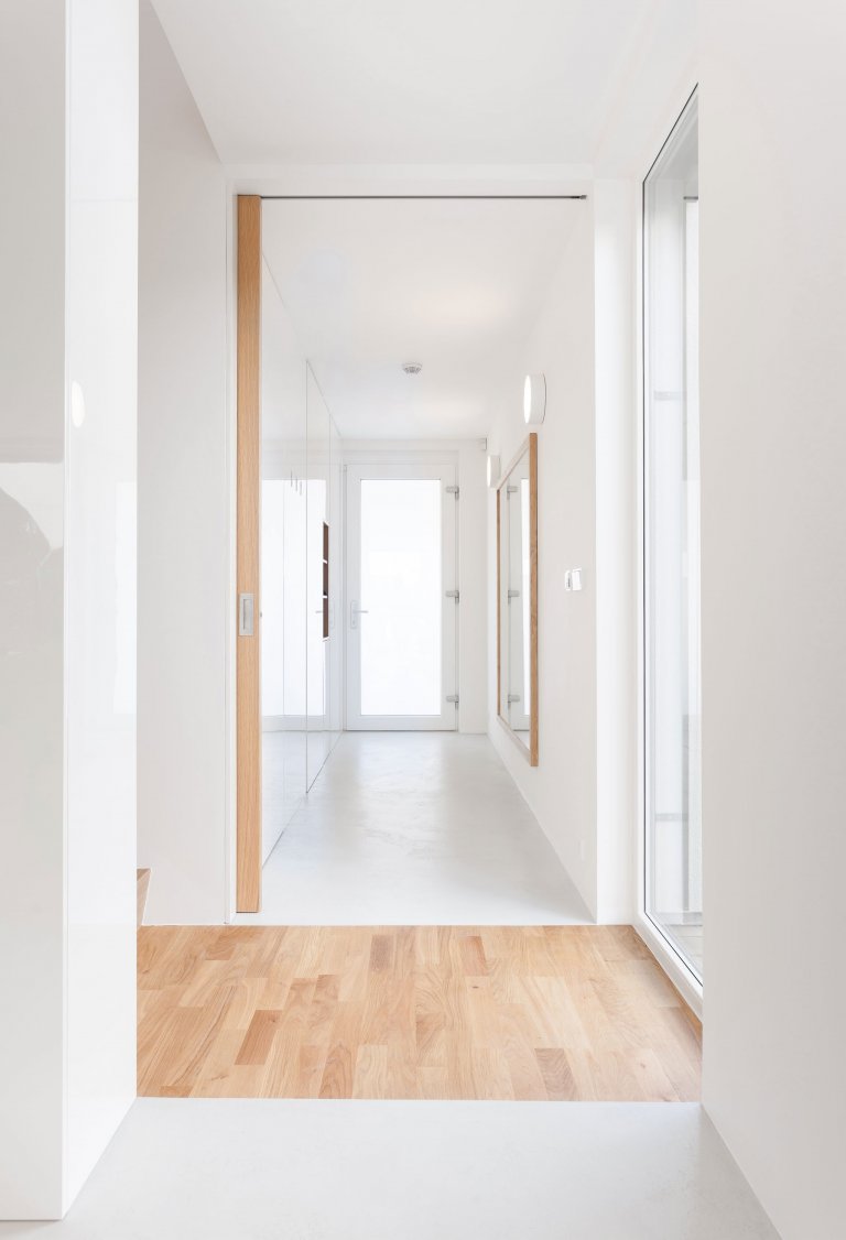 Strohá geometrie a bílá barva v&nbsp;kombinaci s&nbsp;přírodním olejovaným dubem a antracitově šedými plochami jako podklad pro barevné hrátky v&nbsp;prostoru.…