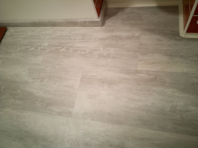 Další detail vinylové podlahy včetně soklové lišty se stejným dekorem jako podlaha