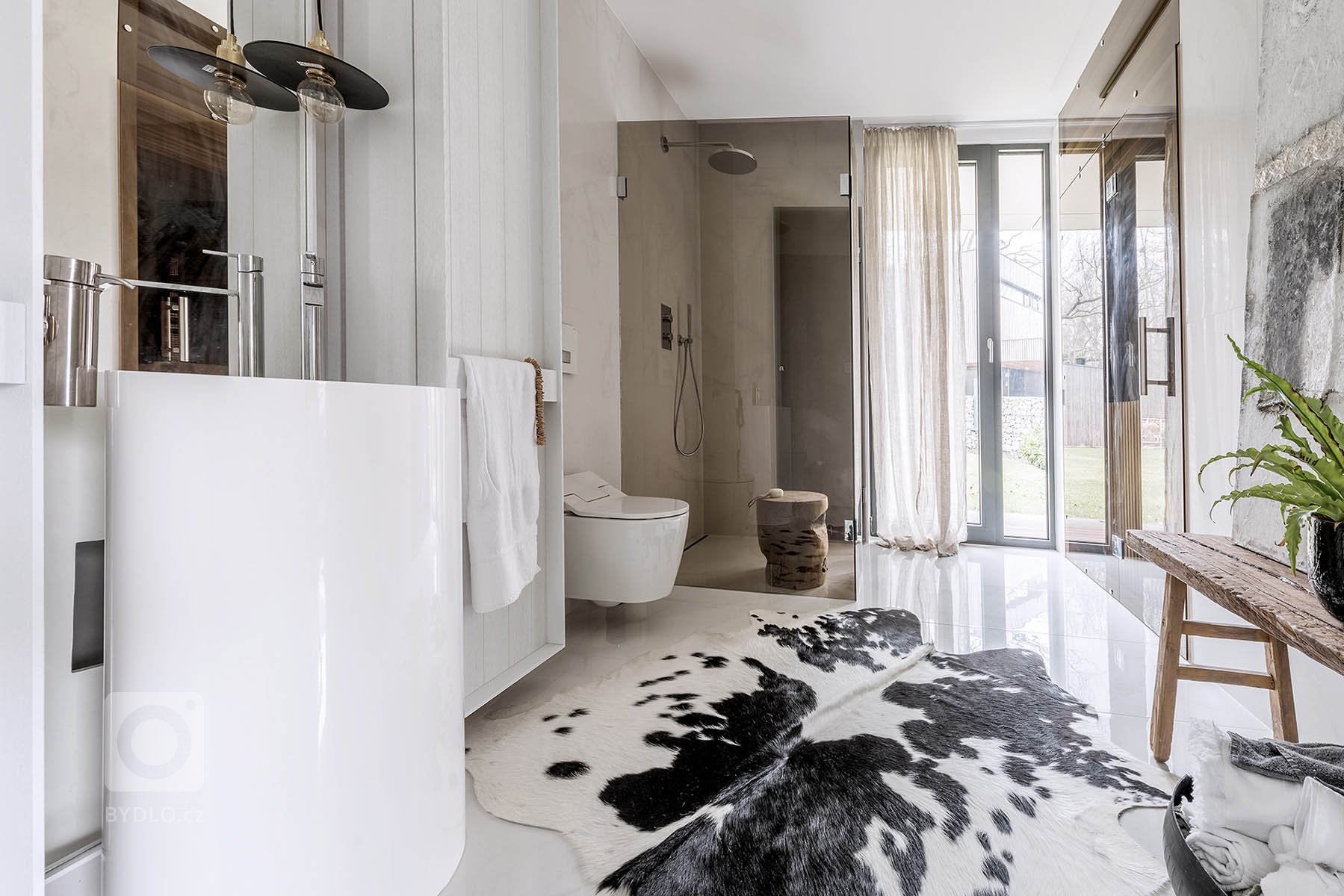 Dispozice domu je rozdělena do dvou podlaží. Strohá geometrie s pravoúhlými liniemi nábytku a prostorové bílé struktury probíhají interiérem a tím celý prostor…