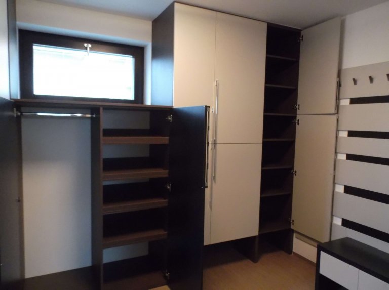 Vnitřní vybavení skříní. Prostor na věšení delších kabátů.  Úplně vpravo jsou police na ukládání kabelek. 