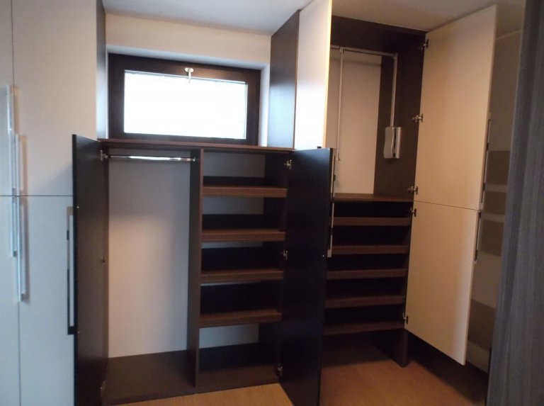 Vnitřní vybavení skříní. Dva prostory vedle sebe  mají nakloněné police na boty a nahoře opět pantograf. 