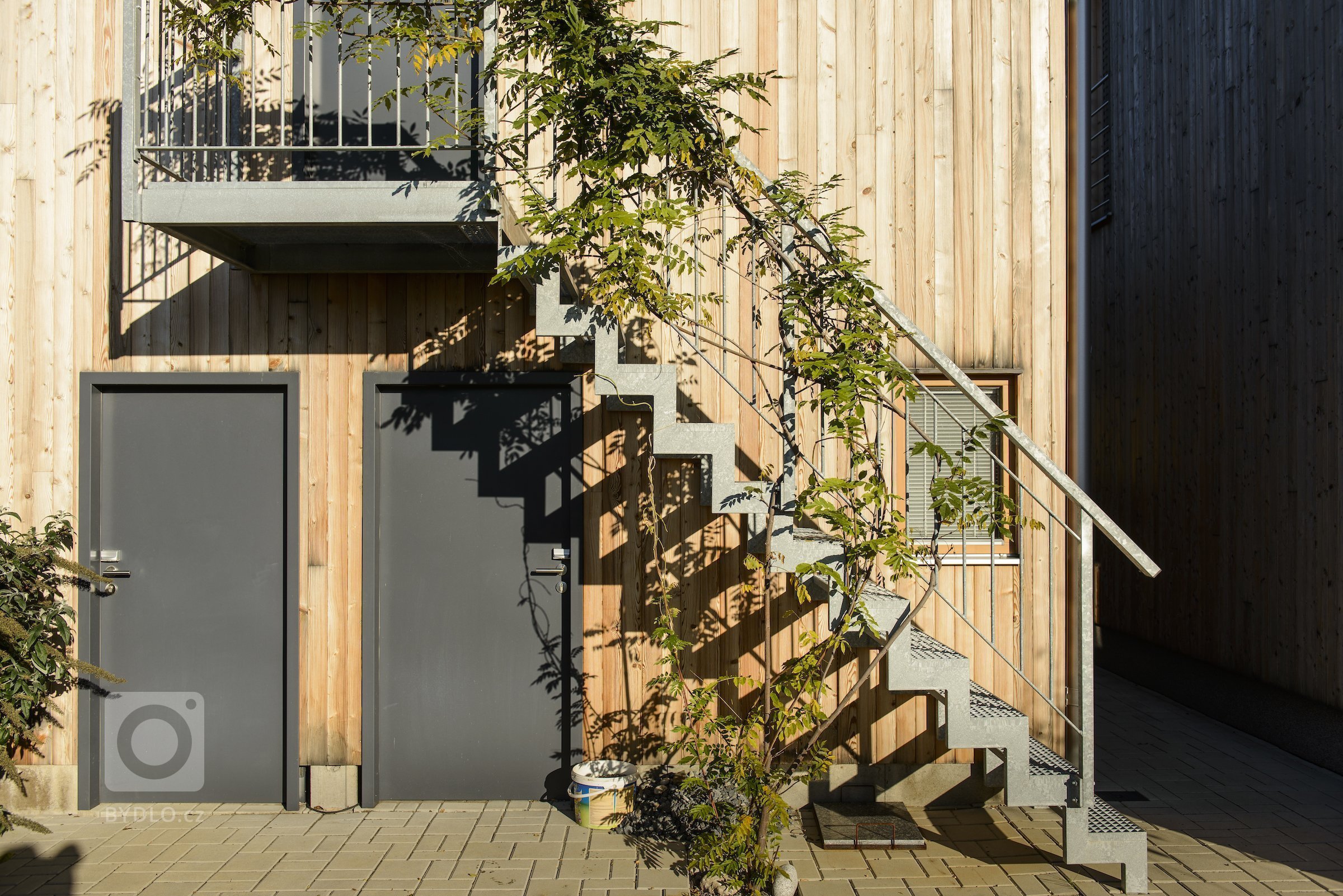 Moderní dřevostavba&nbsp;v&nbsp;pasivním standardu&nbsp;pro mladou rodinu, citlivě zasazená do stávající zástavby historické obce na okraji Prahy, složena ze…