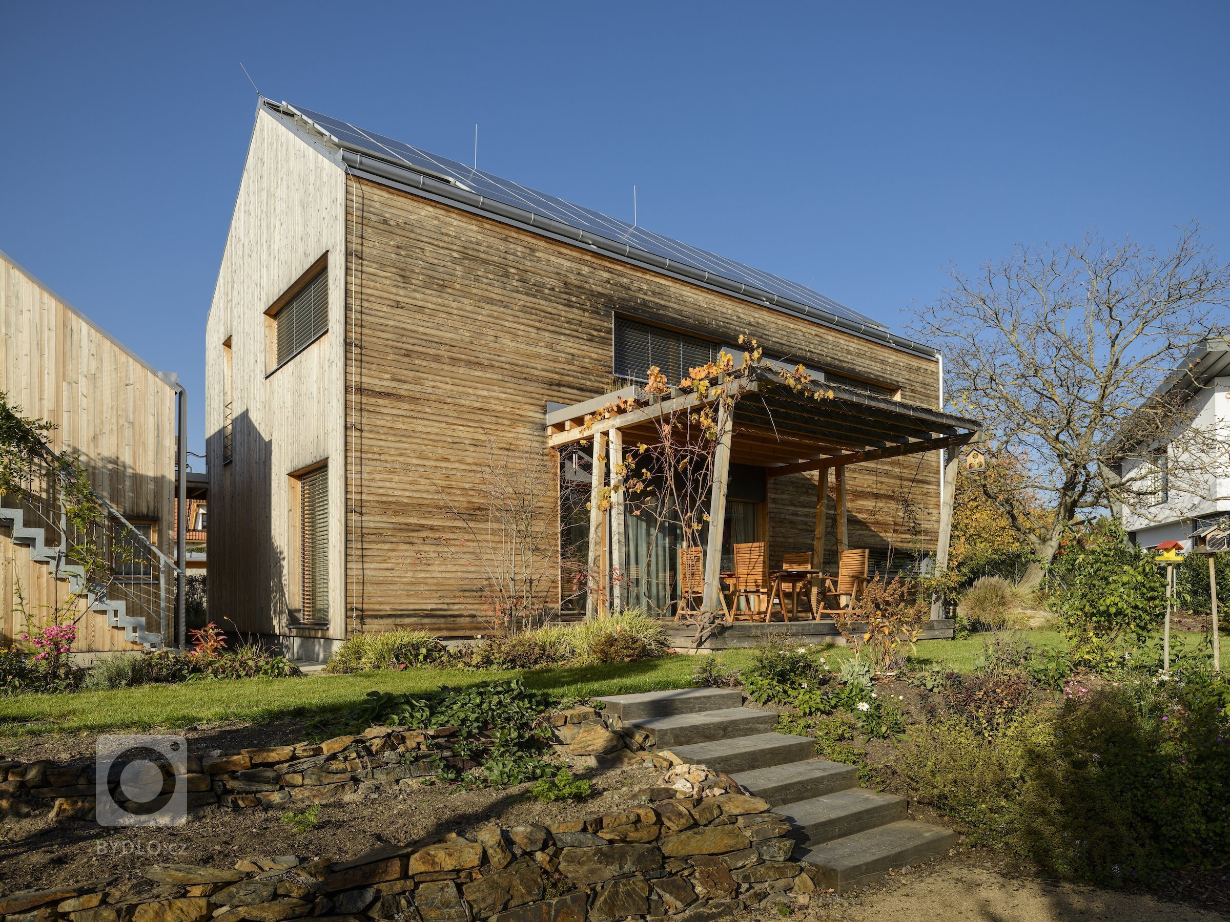 Moderní dřevostavba&nbsp;v&nbsp;pasivním standardu&nbsp;pro mladou rodinu, citlivě zasazená do stávající zástavby historické obce na okraji Prahy, složena ze…