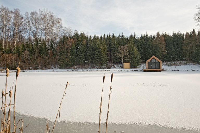 Inspirováná tradičními rybářskými boudami na břehu rybníka, zasazeného v&nbsp;malebné krajině&nbsp;Vysočiny
