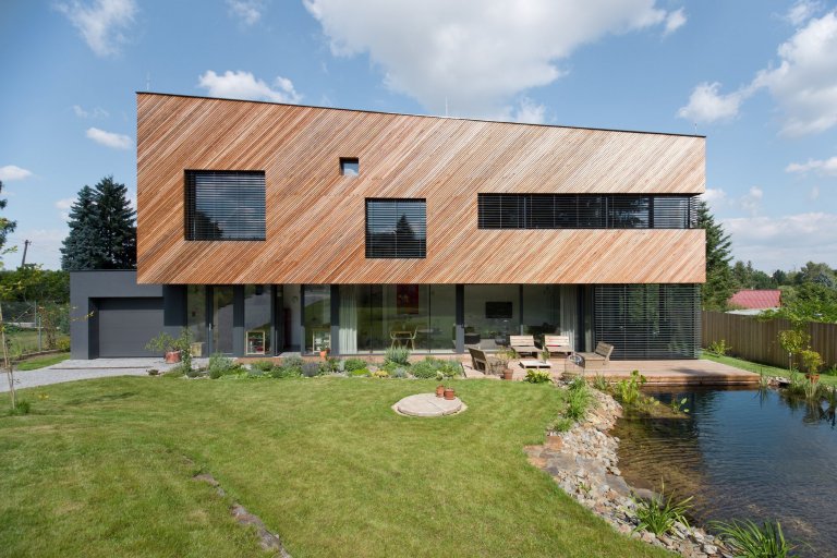 Architektonické řešení navazuje na zahrádkářskou minulost parcely a koncept projektu řadových domů. Protáhlá obdélníková stavba má plně prosklené přízemí, na…