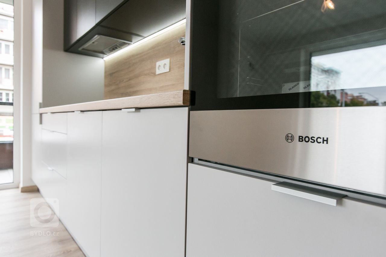 Použité materiály:

Horné skrinky: antracitový mat
Dolné a vysoké skrinky:&nbsp;biely perleťový mat
Vstavané skrine: biely perleťový mat
Výklenok: dub…