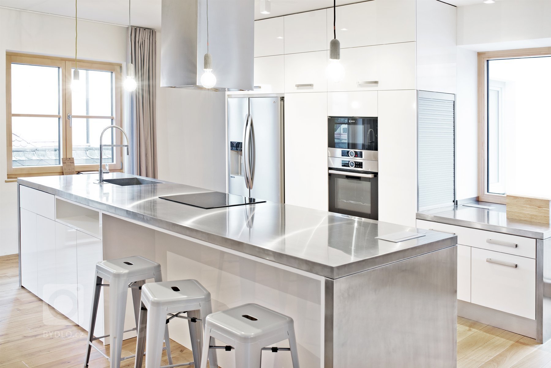 Sofistikovaný moderní vzhled kuchyně hraje hlavní roli v&nbsp;obytném prostoru zrekonstruovaného podkrovního bytu. Kuchyně je se zbytkem pokoje, který slouží…