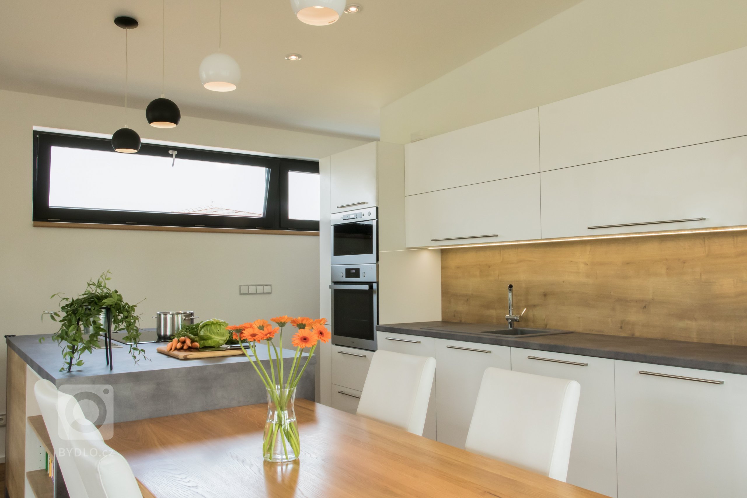 Kuchyňská linka je navržena ve dvou liniích s navazujícím jídelním stolem. Klasickou kombinaci bílé a dekoru dubového dřeva obzvláštňuje šedý akcent v podobě…