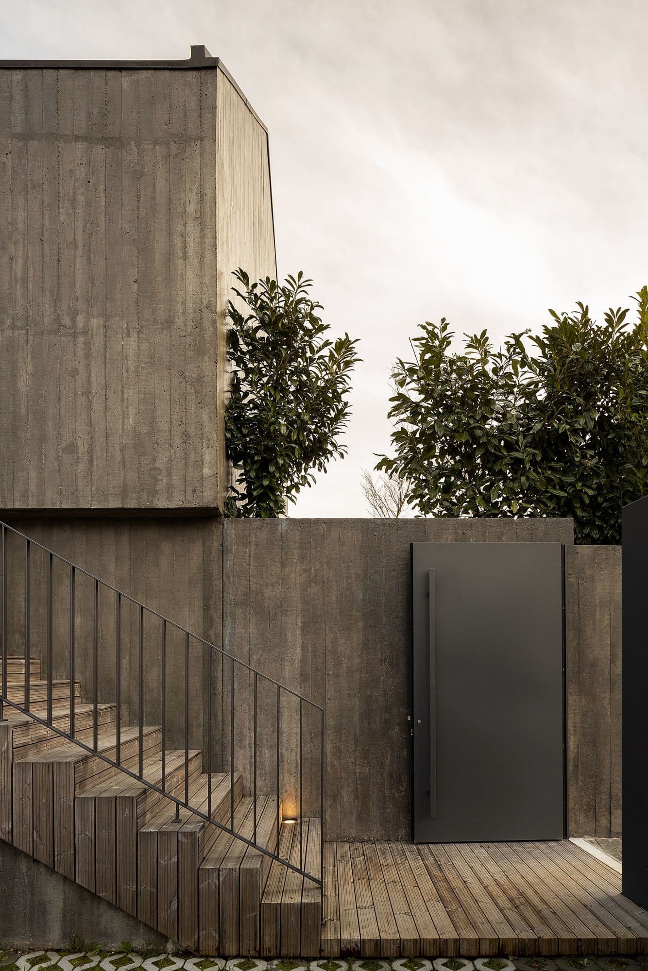 Dům s dřevěnou fasádou a geometrickými světlíky