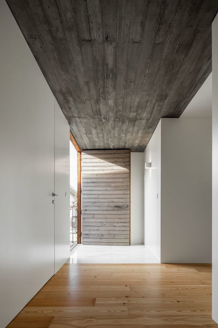 Dům s dřevěnou fasádou a geometrickými světlíky