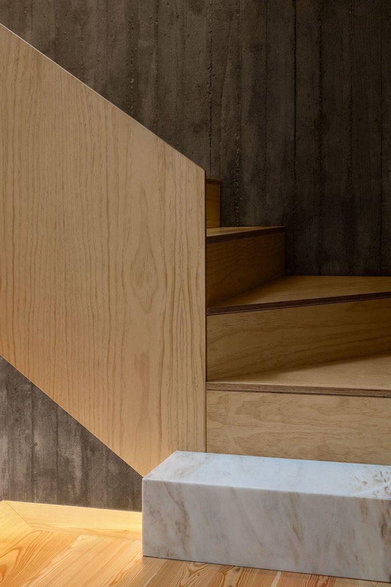 Dům s dřevěnou fasádou a geometrickými světlíky