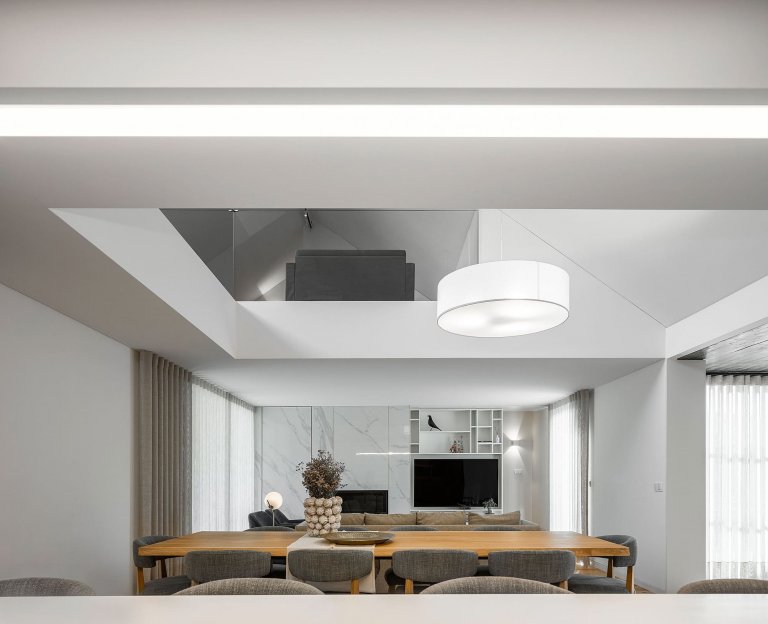 Dům s dřevěnou fasádou a geometrickými světlíky