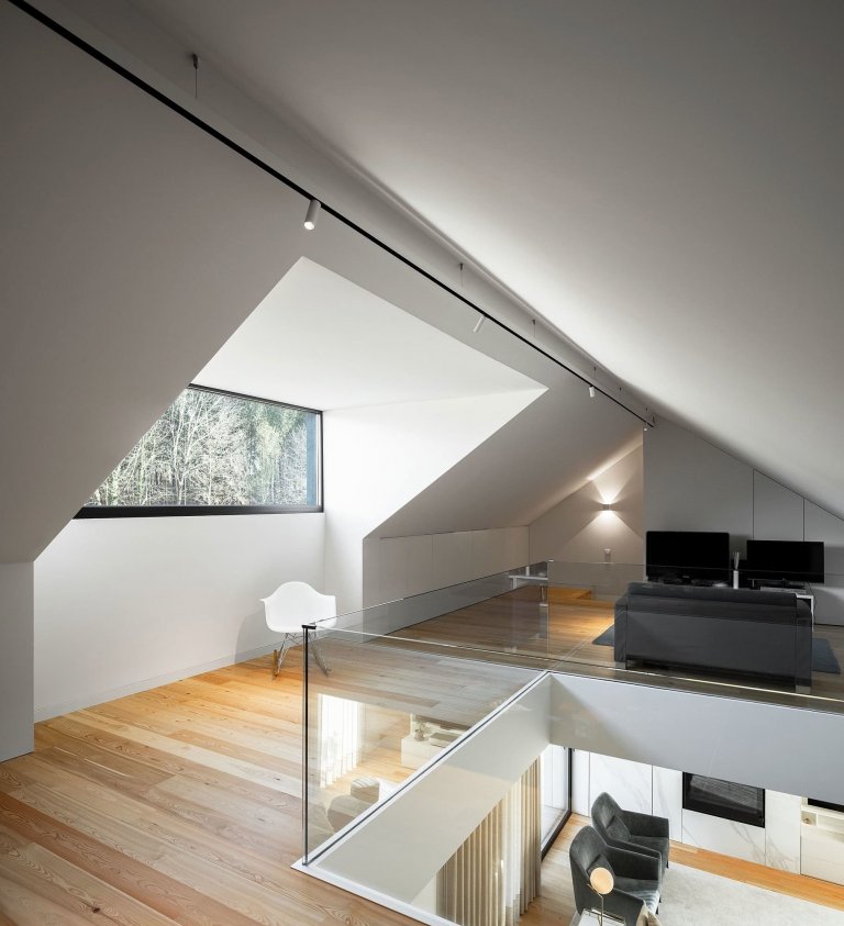 Dům s dřevěnou fasádou a geometrickými světlíky