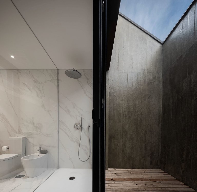 Dům s dřevěnou fasádou a geometrickými světlíky