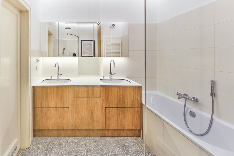 Rekonstrukce bytu s modrou kuchyní a knihovnou