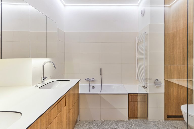 Rekonstrukce bytu s modrou kuchyní a knihovnou