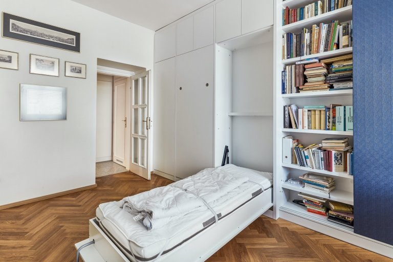 Rekonstrukce bytu s modrou kuchyní a knihovnou