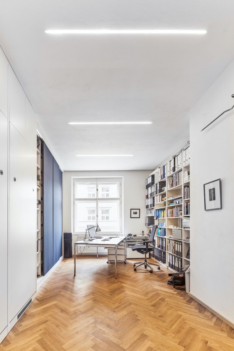 Rekonstrukce bytu s modrou kuchyní a knihovnou