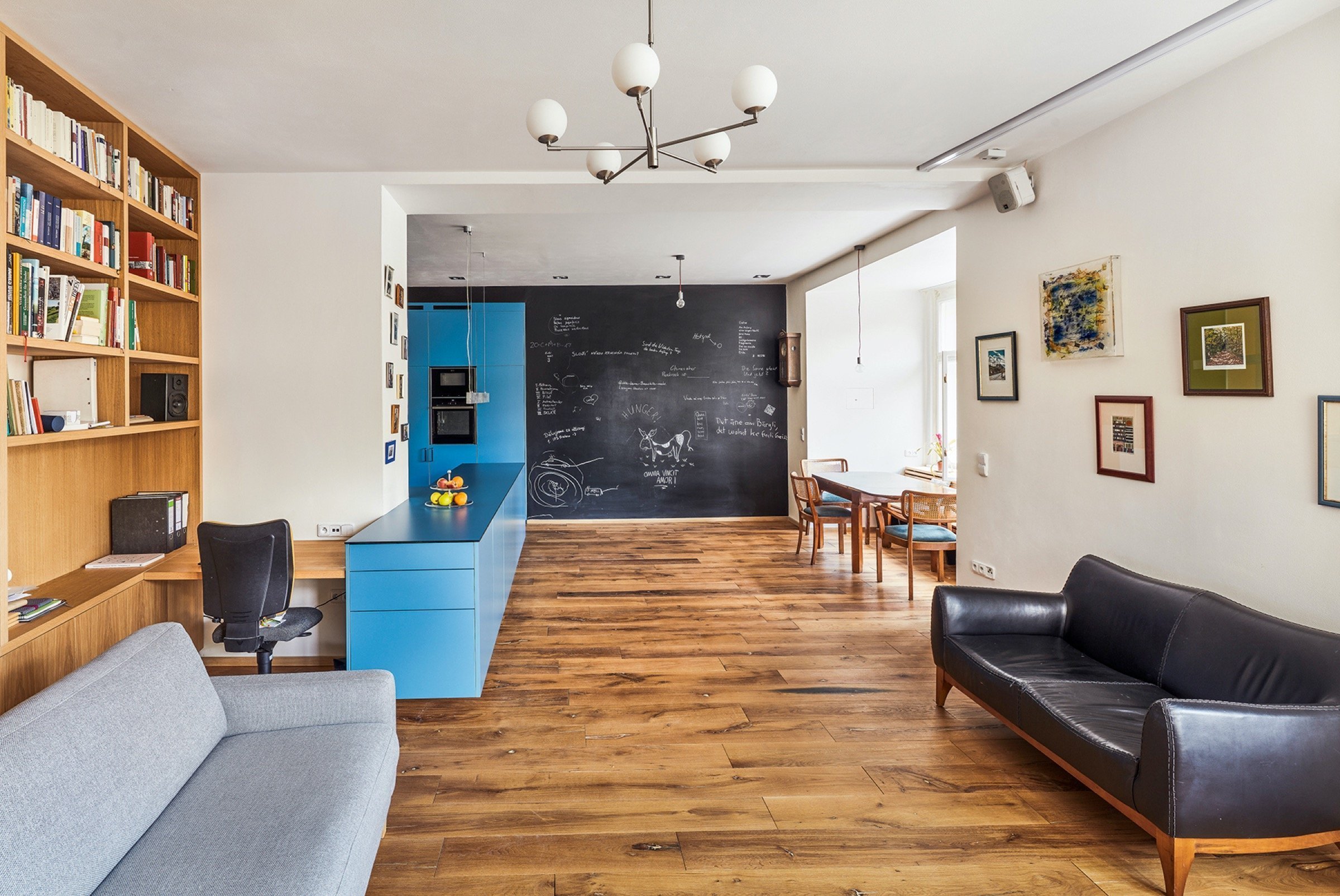 Rekonstrukce bytu s modrou kuchyní a knihovnou