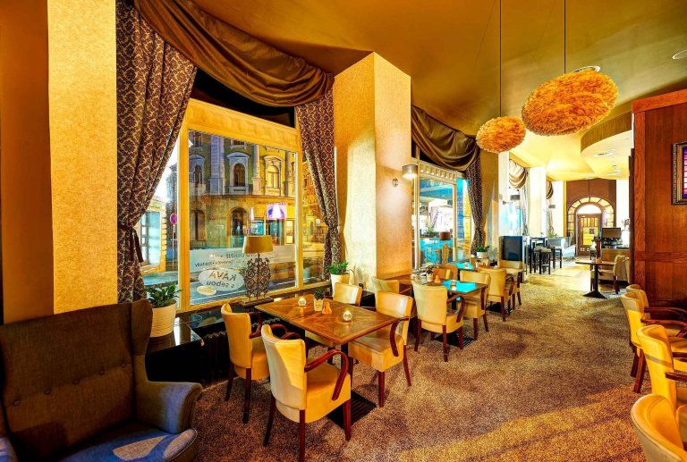 &bdquo;Dobová secesní kavárna s moderním lookem.&ldquo;

Barvy luxusu ve zlatých a hnědých tónech, exklusivní tapety, zámecké závěsy a to vše doladěné husím…