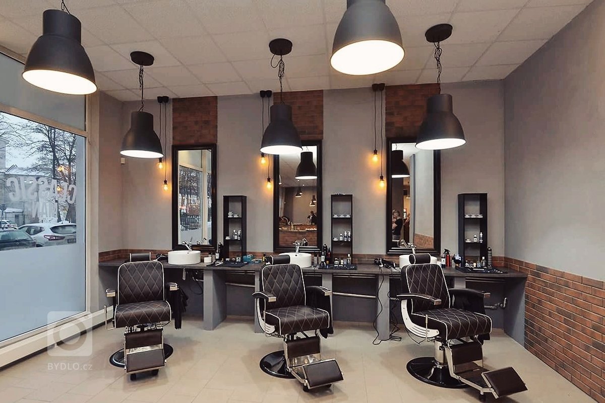 Barber shop je navržen v&nbsp;konceptu tmavých tónů, černých a&nbsp;šedých odstínů a&nbsp;ty jsou doplněné kovovými detaily, industriálními světly, zrcadly,…