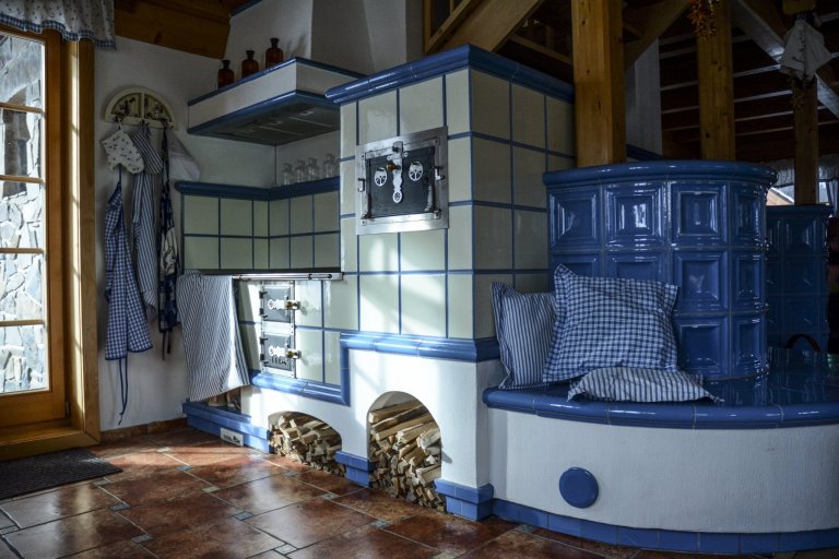 Kachlová kamna s vložkou Olsberg Profi Plus 12 a sporákem na vaření, která vytápějí krásnou roubenku. Nechybí také vyhřívaná lavice. Kachle K&amp;K POKER…