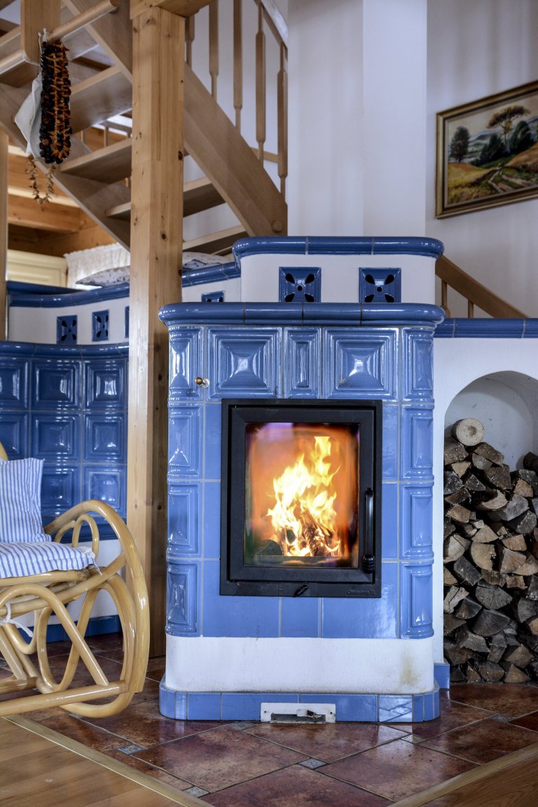 Kachlová kamna s vložkou Olsberg Profi Plus 12 a sporákem na vaření, která vytápějí krásnou roubenku. Nechybí také vyhřívaná lavice. Kachle K&amp;K POKER…