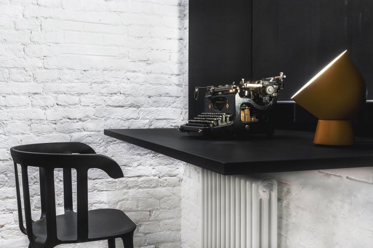 Byt s nábytkem IKEA a černou cihlovou zdí