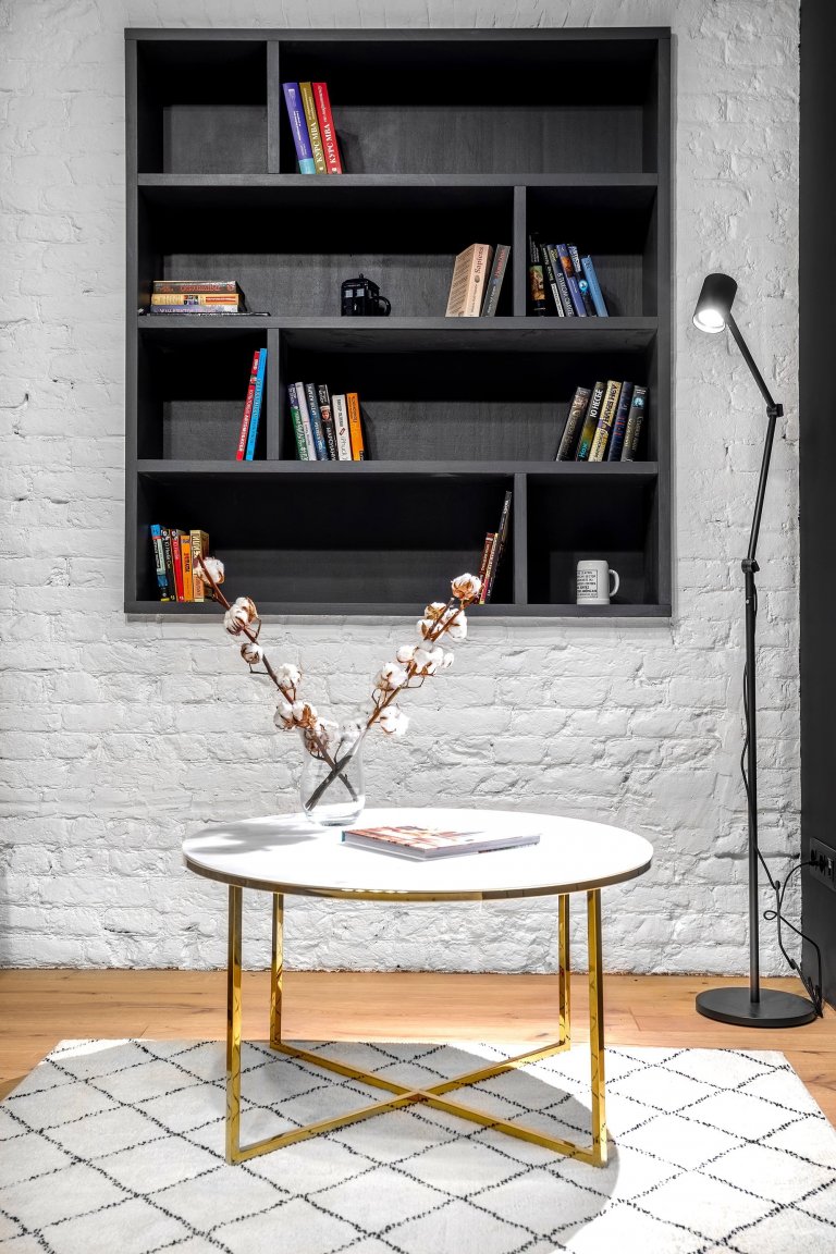 Byt s nábytkem IKEA a černou cihlovou zdí