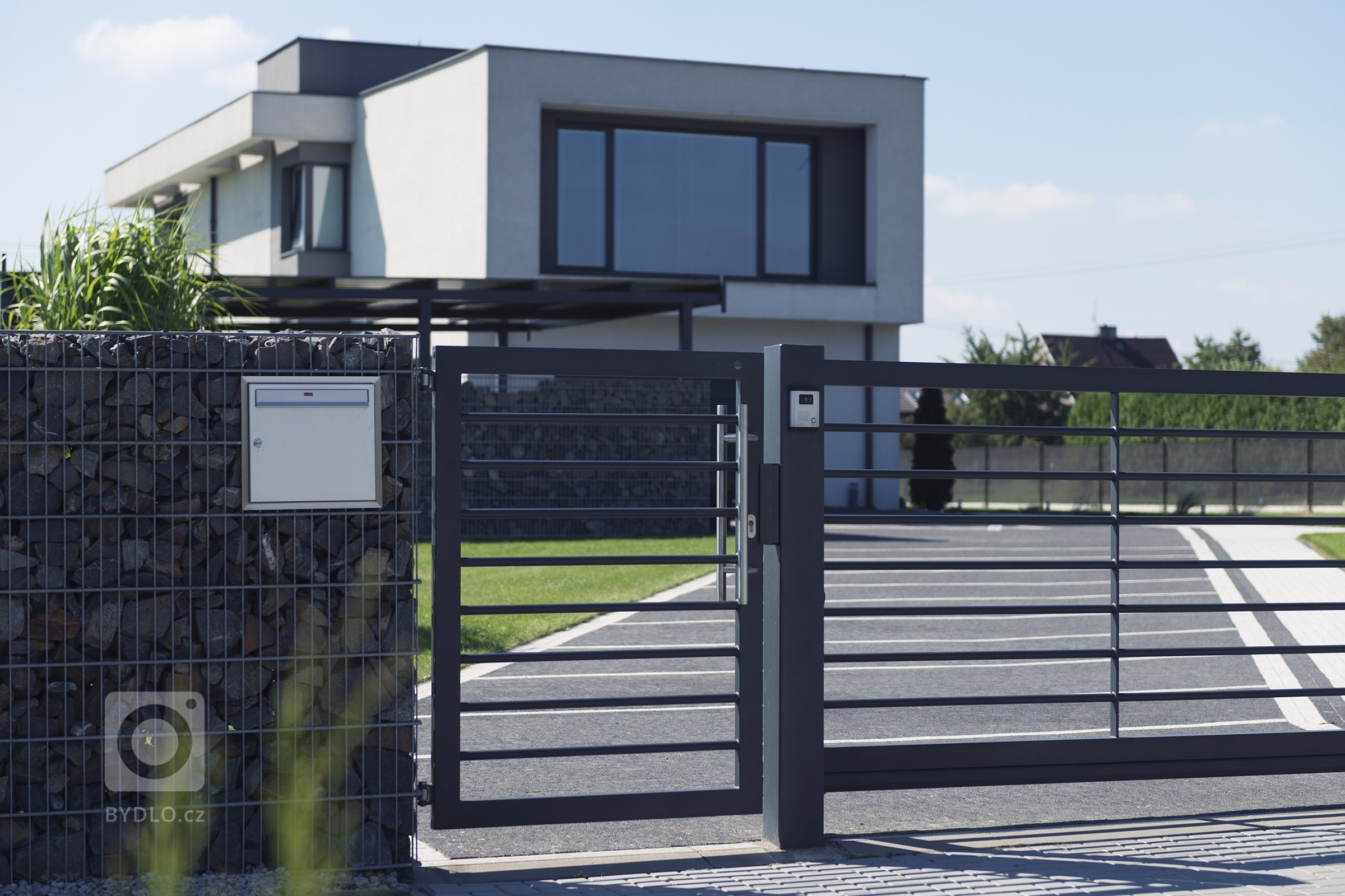 Vjezd v designu Airy, kombinovaný s gabiony Rock (rodinný dům, Orlová).

Funkcionalisticky pojatý dům, kde se slušelo nechat prostor okolo dýchat. Navrhli…