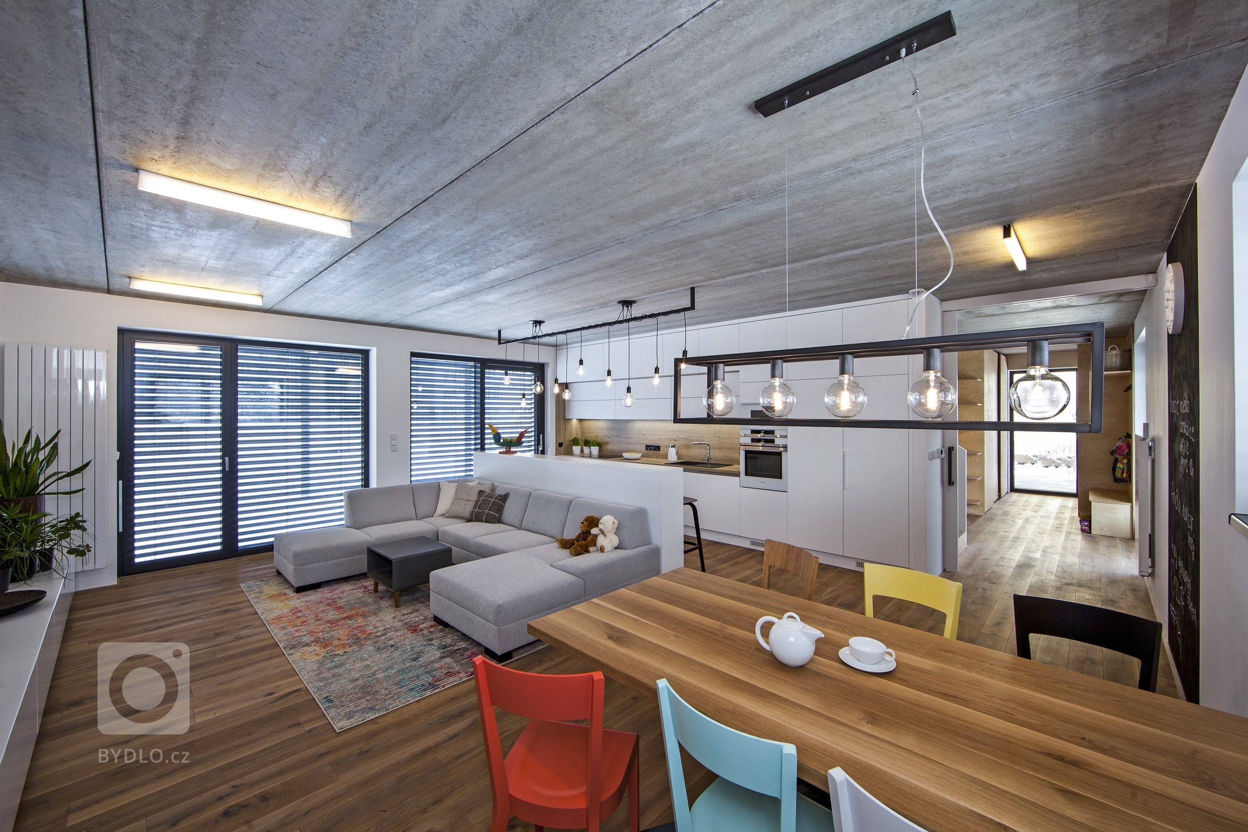 V celém domě se prolínají přírodní materiály s černými kovovými prvky a detaily s bílými stěnami a dveřmi. Industriální ráz podtrhují přiznané betonové stropy…