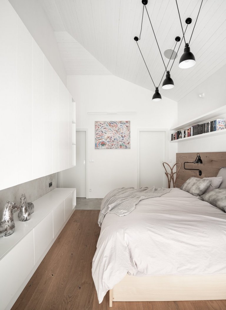 Aby bílý nábytek nesplýval se stěnou byl podtržen šedou betonovou stěrkou.