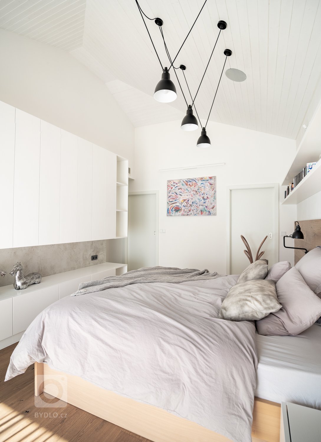 Ačkoliv je ložnice malá, nepůsobí stísněným dojmem. Přičinil se k tomu vysoký strop a světlé barvy. 