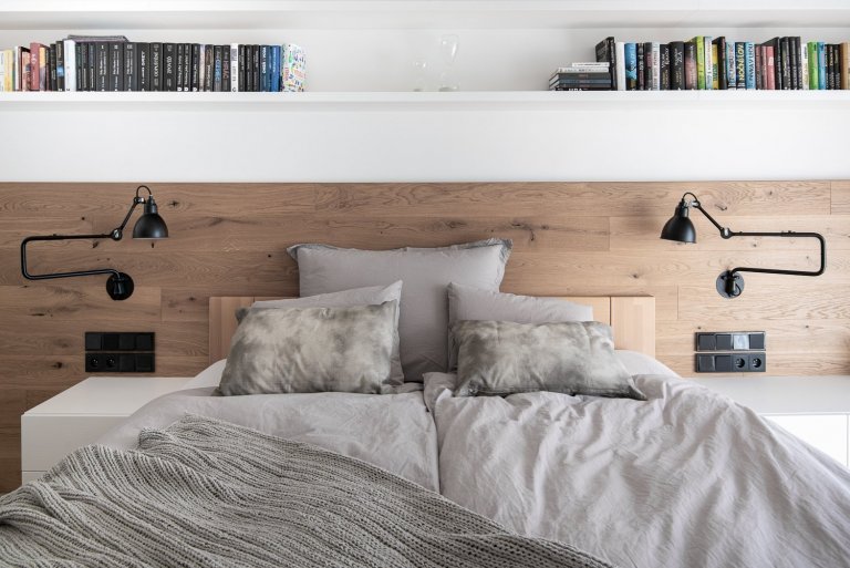 Pokud hovoříme o čistých liniích, tak nemůžeme opomenout ani dlouhou polici na knihy, čtecí lampičky a výrazné černé osvětlení nad postelí.