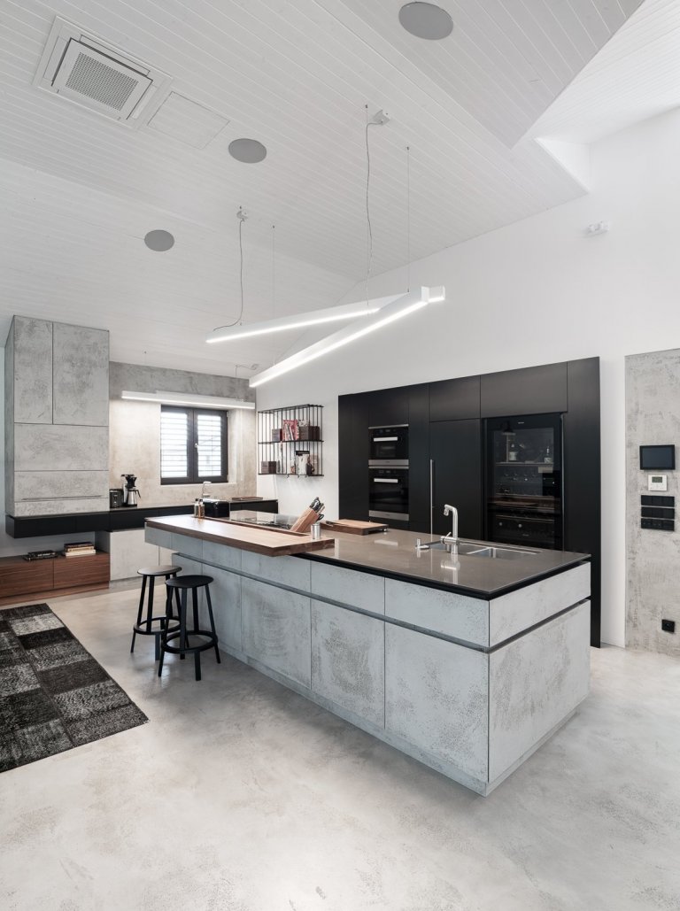 Povrchová úprava kuchyňské linky je betonová stěrka od Němce. Její odlehčený a přísný vzhled umocňují detaily v podobě zkosených hran u čel zásuvek.