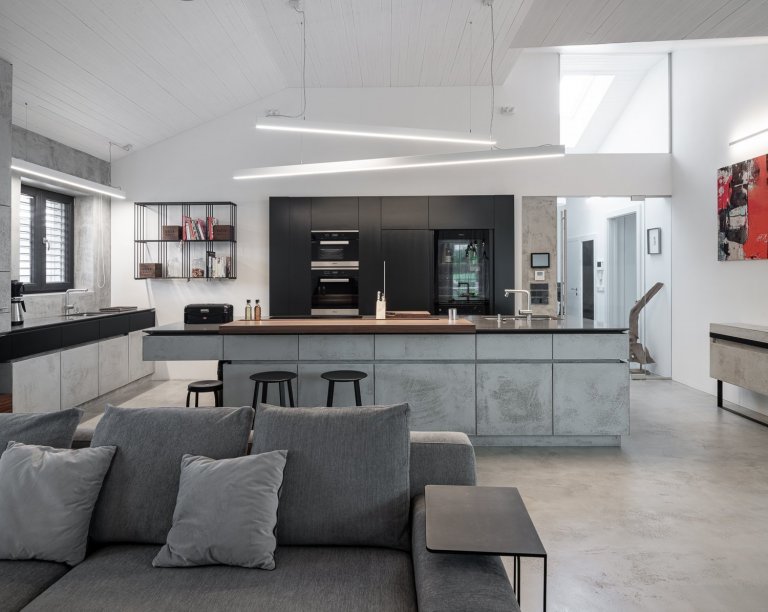 Povrchová úprava kuchyňské linky je betonová stěrka od Němce. Její odlehčený a přísný vzhled umocňují detaily v podobě zkosených hran u čel zásuvek.