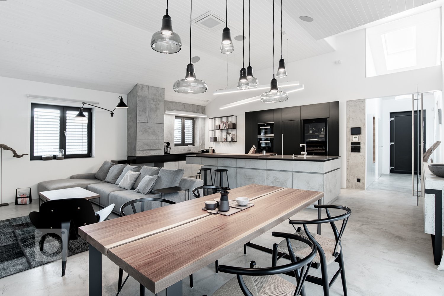 Velkým plochám dominuje bílá barva na stěnách, stropu a podlaze. Dále pak světle šedá betonová stěrka na nábytku.