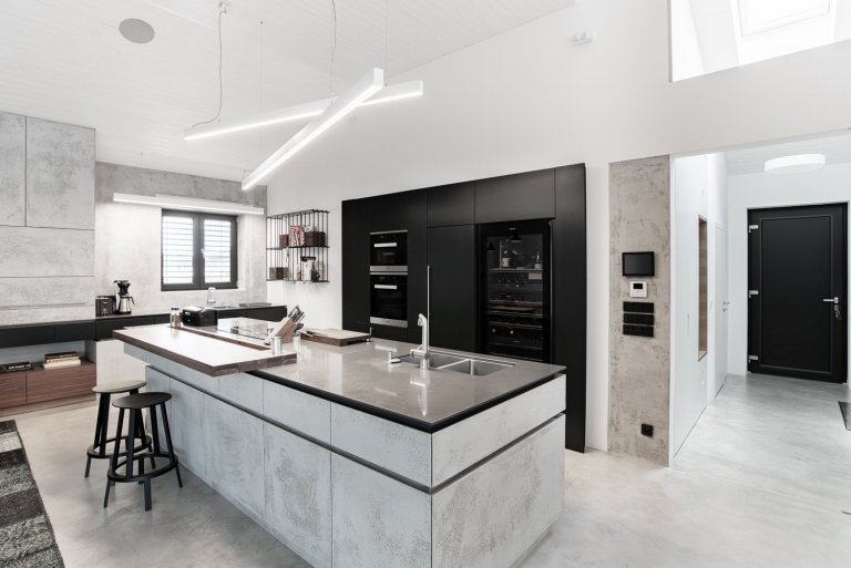 Velkým plochám dominuje bílá barva na stěnách, stropu a podlaze. Dále pak světle šedá betonová stěrka na nábytku.