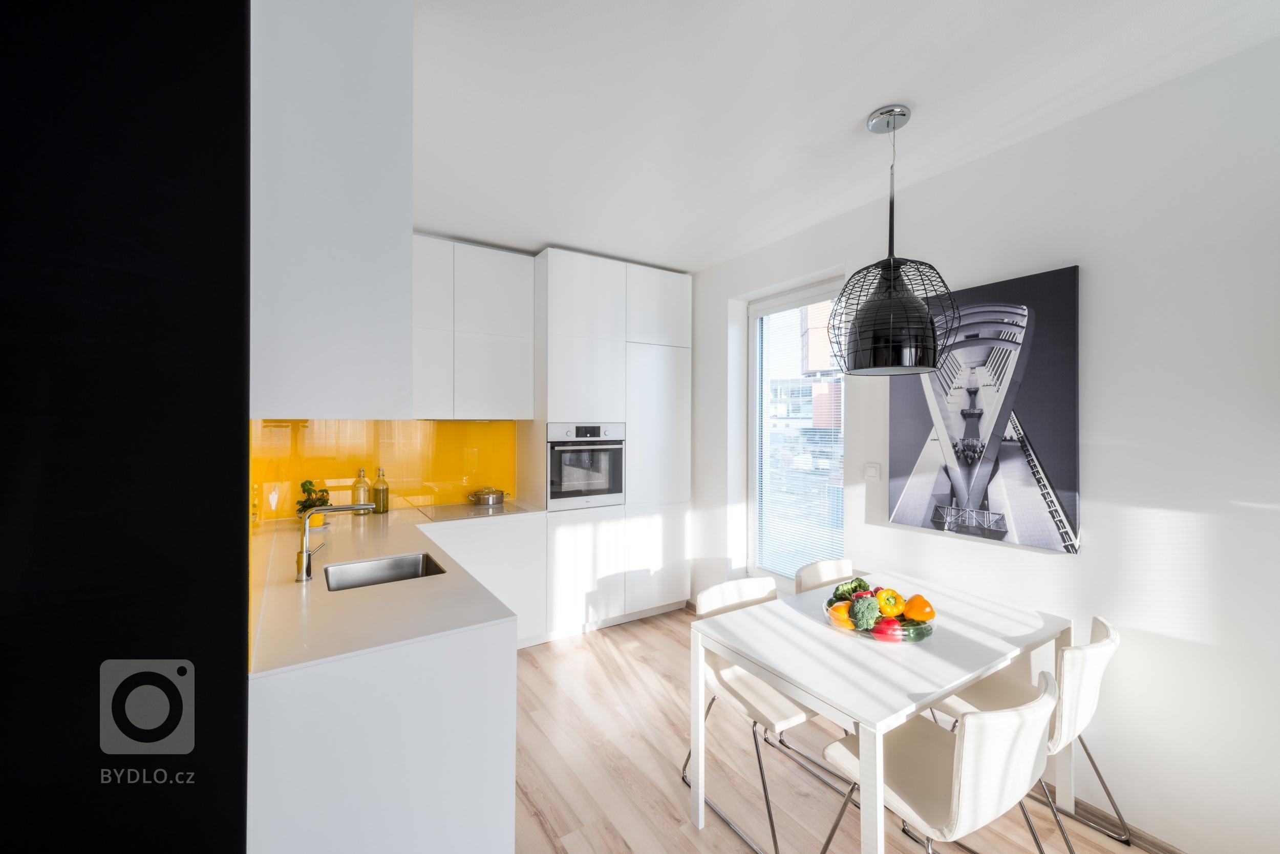 Optimistický interiér malého bytu obsahuje minimum zbytečností, proto působí čistě a prostorně. Velkoplošné fototapety z portfolia majitele zvětšují měřítko…