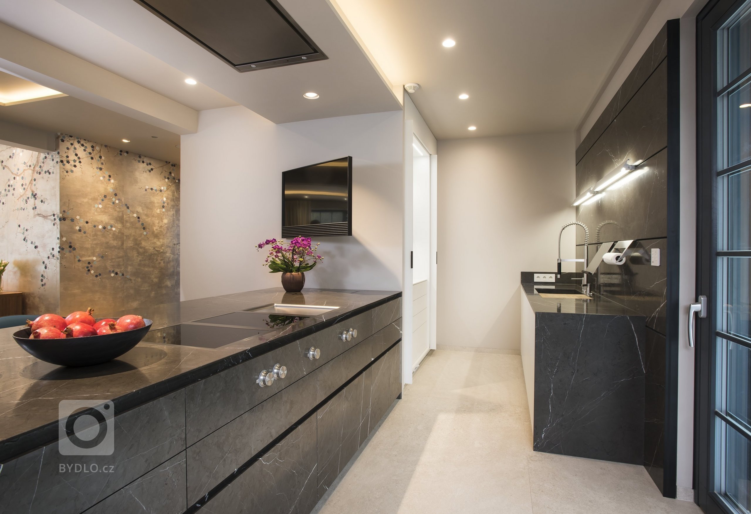 Kuchyň EGGERSMANN UNIQUE, rodinný dům. Provedení je masivní kámen Graphit Brown Leather na ostrůvku v&nbsp;kombinaci s Paso supermatt lotus white a broušeným…