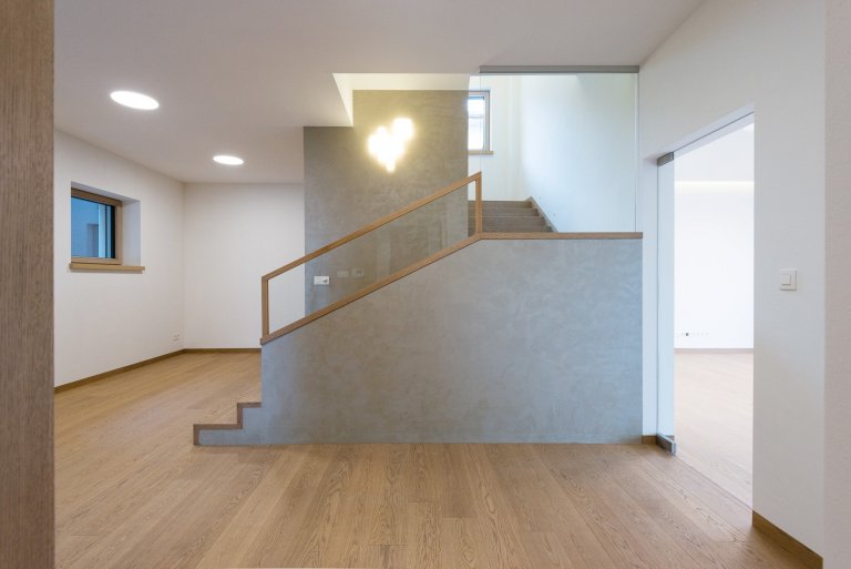 Elegantný a moderný interiér rodinného domu realizovaný pomocou prírodných materiálov v kombinácii s umelým kameňom a lamino povrchom.
