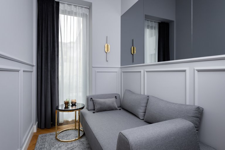 Hostovská místnost - jedná se o velmi malou místnost o velikosti 6 metrů čtverečních. Pohovka na míru má snímatelné područky a polštáře a lze s ní vytvořit lůžko 120 cm široké. Pro optické rozšíření místnosti jsme nad obložení instalovali kouřová zrcadla.