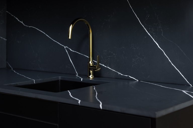 Detail na pracovní desku s mosaznou baterií.