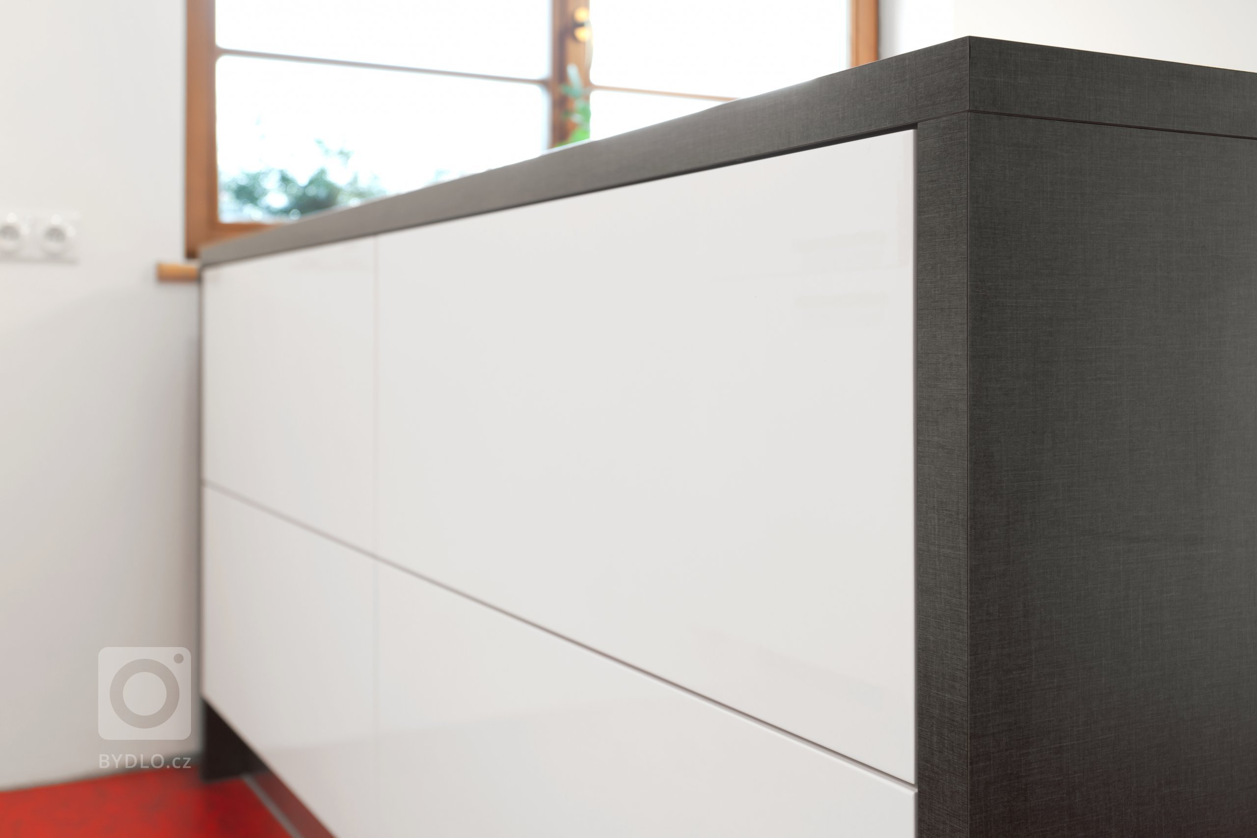 Představujeme vám kuchyň jednoduchých tvarů a dramatických kontrastů. Bílé plochy, které tvoří robustní základ celé kuchyně, lemuje strukturovaný tmavý povrch,…